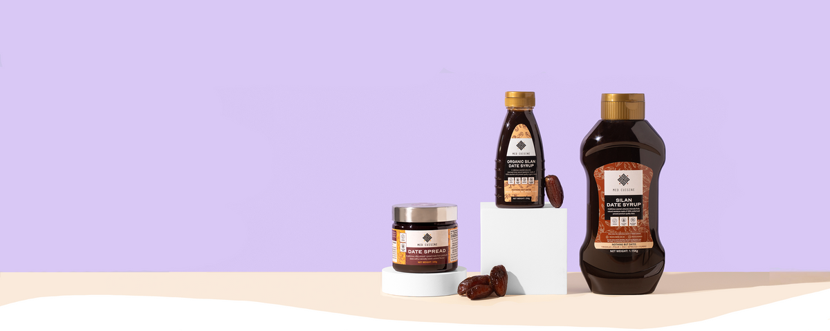 Organic silan date syrup and date spread standing against a lavender background. 